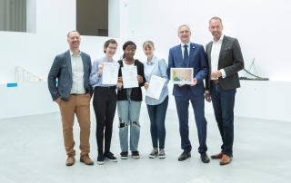 Preisübergabe im Baukunstarchiv NRW (v. l.): Patrick Diedrich (Freiherr-vom-Stein-Gymnasium), Katharina, Samuwala, Hannah (Gewinnergruppe), Christoph Spieker (Hauptgeschäftsführer IK-Bau NRW) und Markus Lehrmann (Geschäftsführer Baukunstarchiv NRW und HGF Architektenkammer NRW) – Foto: John M. John