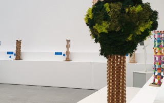 Modelle von Turmbauten: Im Vordergrund steht ein Modell, das einem Baum ähnelt. Im Hintergrund sind Modelle aus Papier und Holz auf weißen Sockeln positioniert.