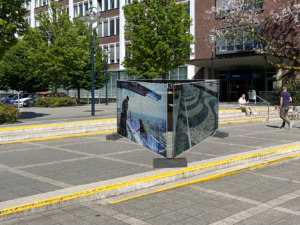 Bauzäune im öffentlichen Raum, dahinter sind Pflanzen, Gebäude und Menschen. - Bildcredit: Simulation public preposition: Baukunstarchiv NRW © Studio Mischa Kuball