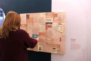 Eine Tafel mit vielen Dokumenten, davor steht eine Person, die sich die Dokumente an der Tafel anschaut.