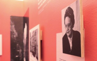 Blick in eine Ausstellung mit Text- und Fototafeln, die in schwarz/weiß dargestellt werden.